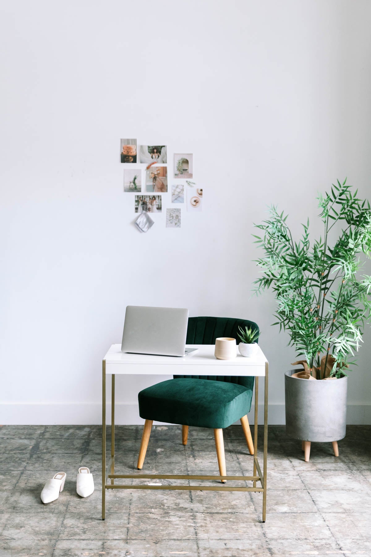 Modern home office with a desk, chair, and plant against a white wall. Owners Society